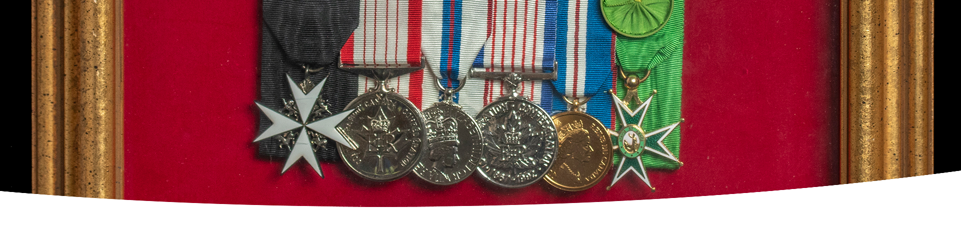 A close-up of a set of medals displayed in a picture frame.