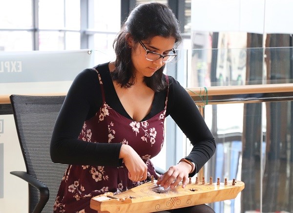 Young woman plays a string instrument.