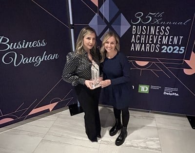 Two women holding an award