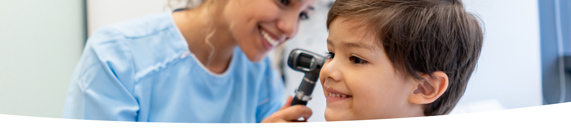 Boy getting his ear checked by a doctor