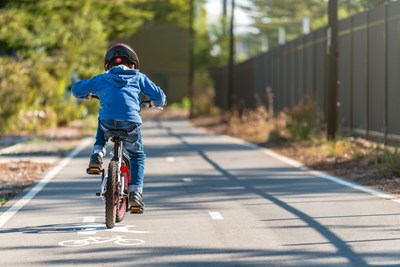 A young child riding a bike in a bike lane.