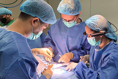 A surgical team performing an operation. One person is wearing a smart glasses headset.