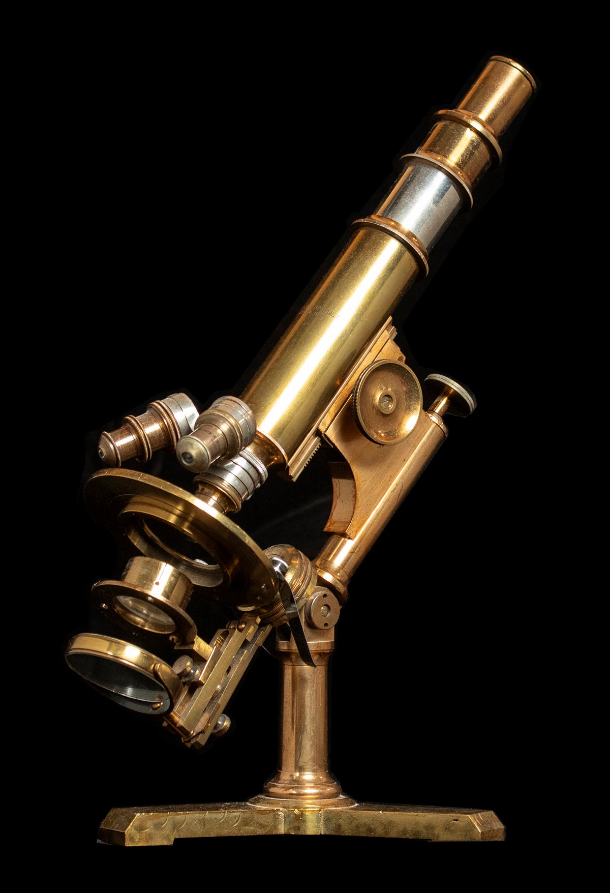 Three-quarters side view of a brass compound microscope.