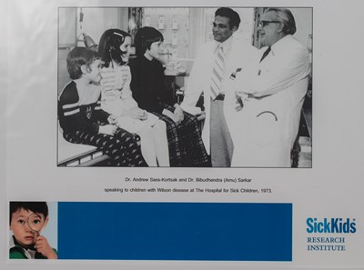 A photo of Dr. Bibudhendra (Amu) Sarkar (left) and Dr. Andrew Sass-Kortsak (right) speaking to three children with Wilson disease at The Hospital for Sick Children, 1973.