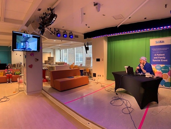 Therapeutic Clown A.Leboo conducts a virtual interview with Maple Leafs player Auston Matthews through a television monitor in Marnie’s Studio.