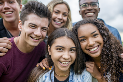 A group of teenagers smile at the camera.