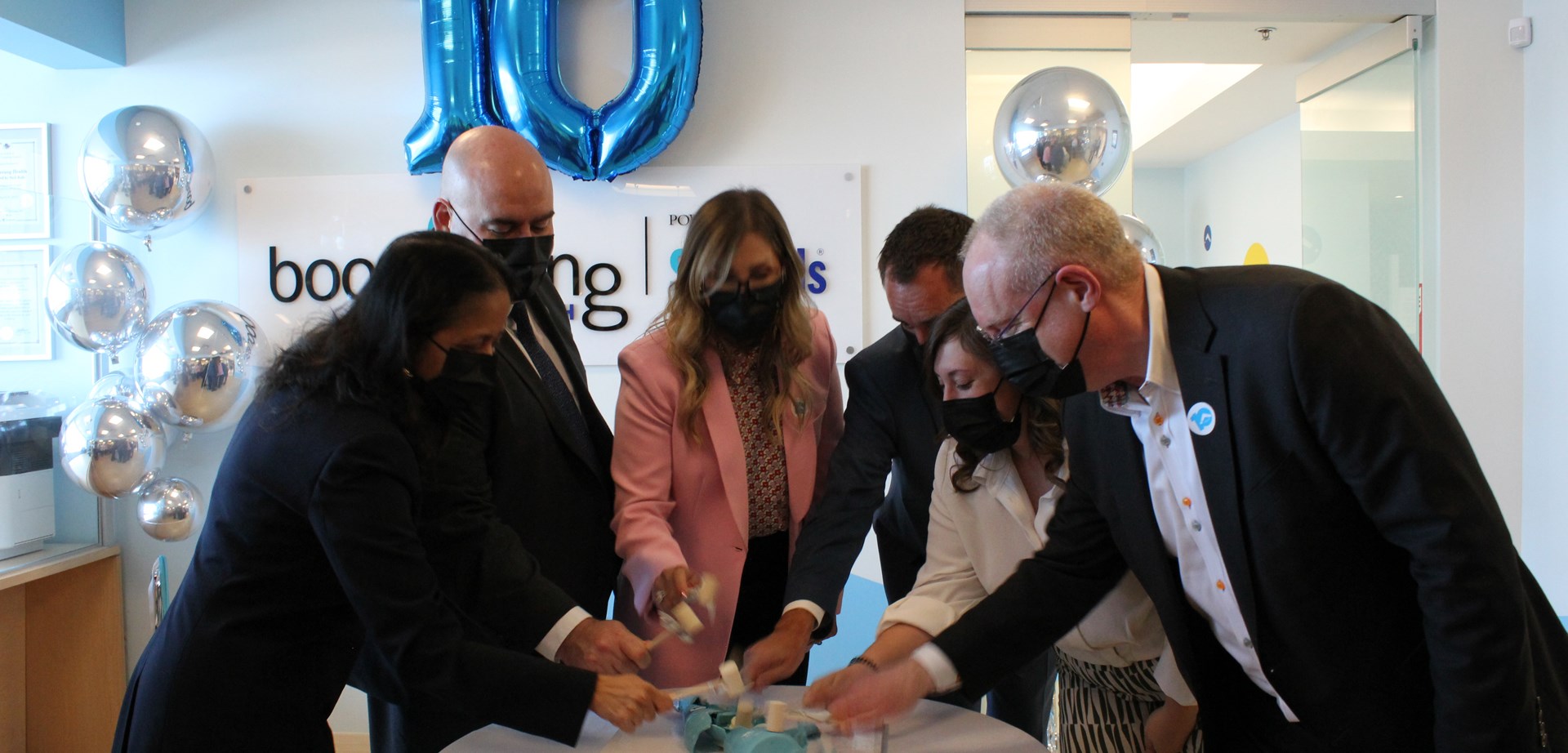 Dr. Madhavi Moharir, Honourable Steven Del Duca, Lara Pietrolungo, Jeff Mainland, Alexandra Ieraci, and Dr. Ronald Cohn in masks celebrating the 10 year anniversary of Boomerang Health.