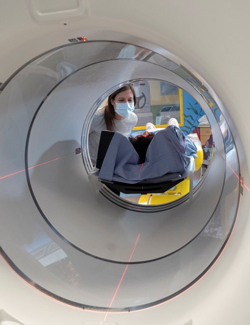 Medical staff preparing a child for a PET scan