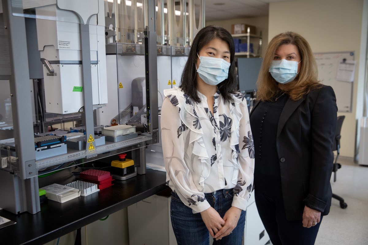 Dr. Kyoko Yuki (left) and Dr. Lianna Kyriakopoulou standing in front of various lab equipment.