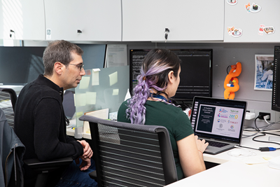 Dr. Adam Shlien examines a computer in his lab.