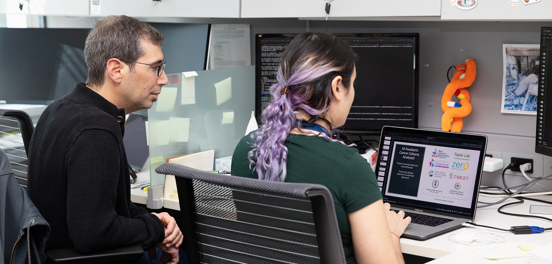 Dr. Adam Shlien examines a computer in his lab.