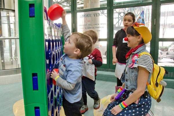 Child plays life-size connect four game.