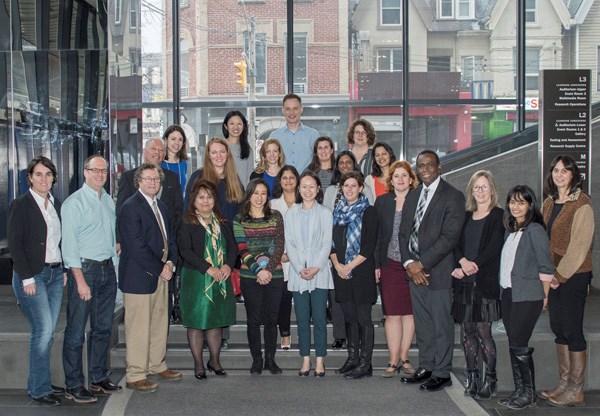 Large group of staff pose together.