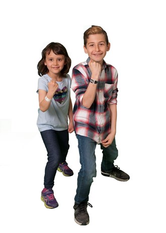 Two kids stand side by side showing new ID bands on their arms.