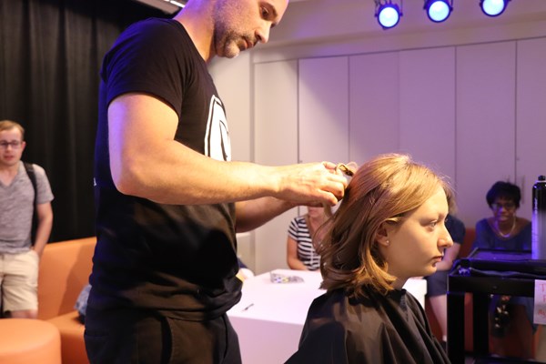 Hair stylist arranges a girl's hair.