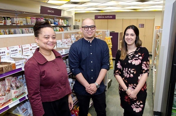 Three staff stand together in the shop.