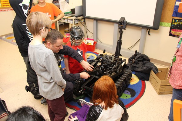 Students gather around a robot.