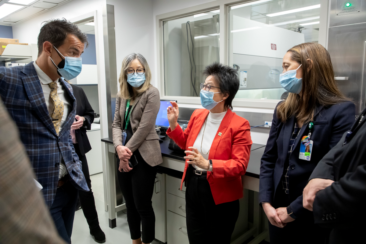 MP Adam van Koeverden speaking with Dr. Fei-Fei Liu, with two other people standing and listening to their conversation.