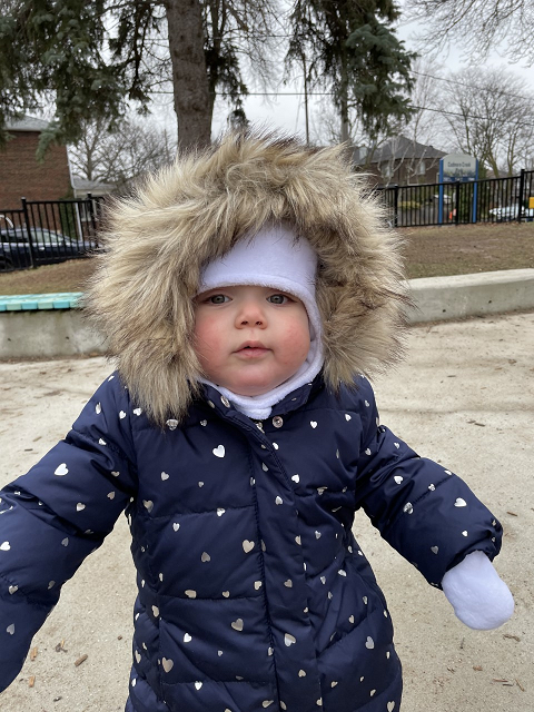 Baby wears a hooded winter coat.