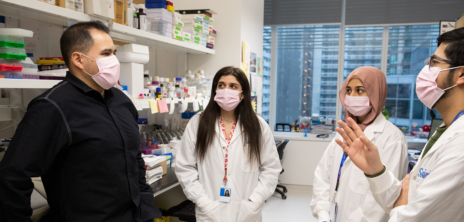 Paul Delgado-Olguin talking with lab members Adar Aharon-Yariv, Mishal Mazhar and Jibran Syed.