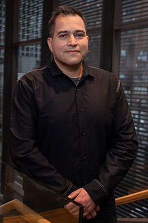 Paul Delgado-Olguin stands at the top of a staircase in the PGCRL.