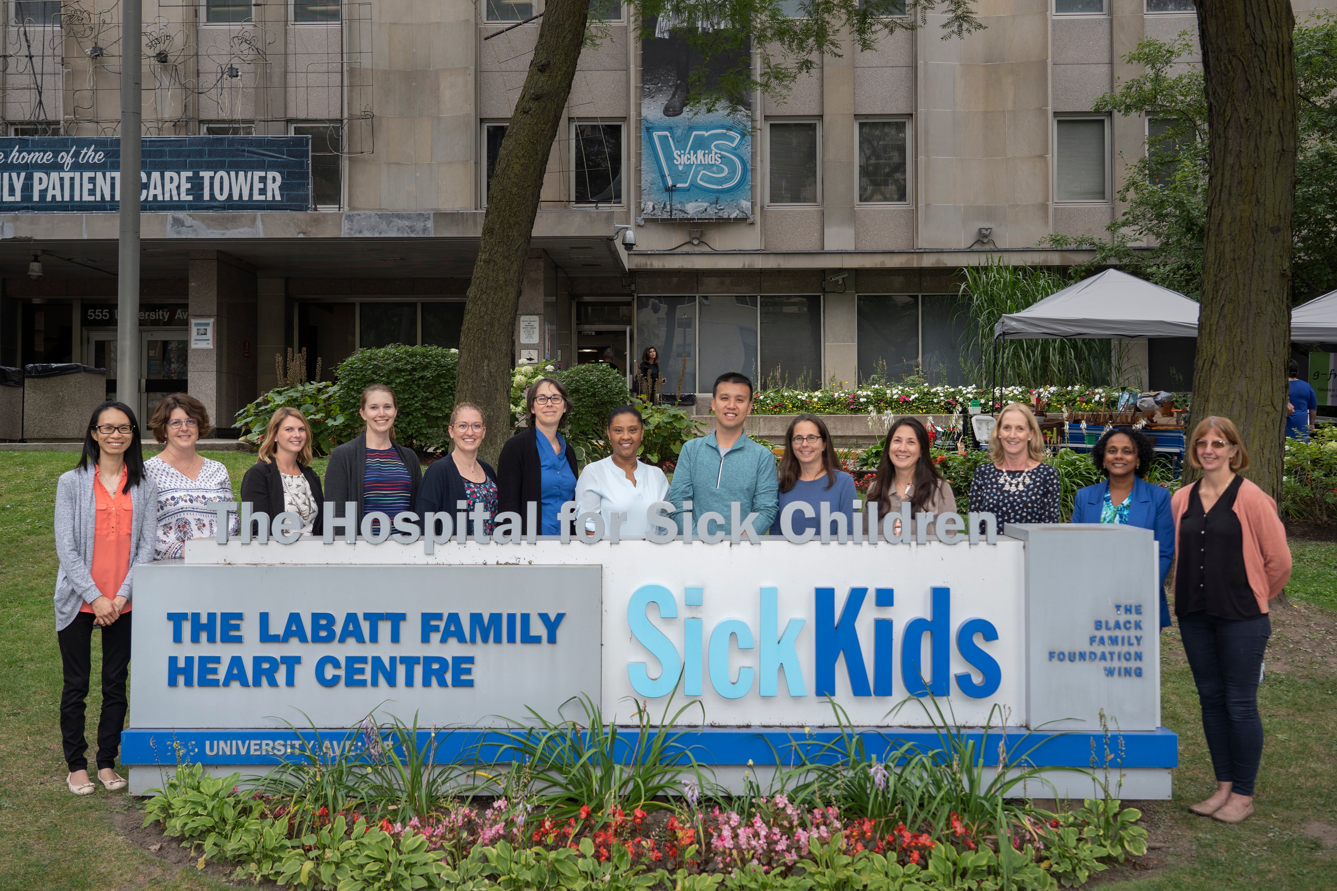 13 Division of Nephrology staff in front of the Hospital smiling for a team photo