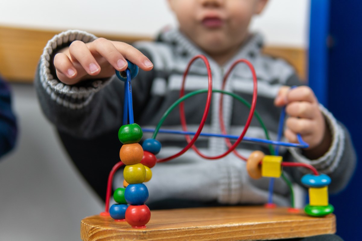 Young boy playing with wooden toy