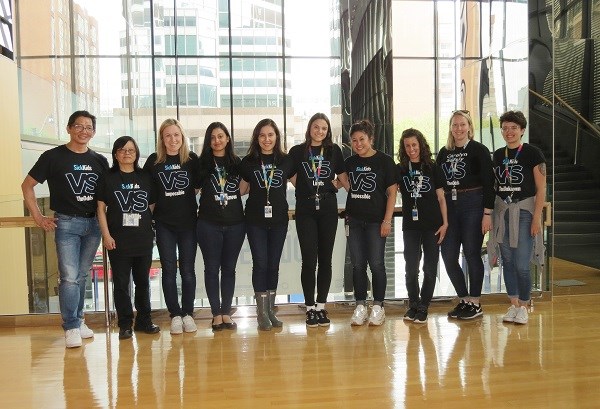 Group of staff in matching SickKids t-shirts pose for a group photo.