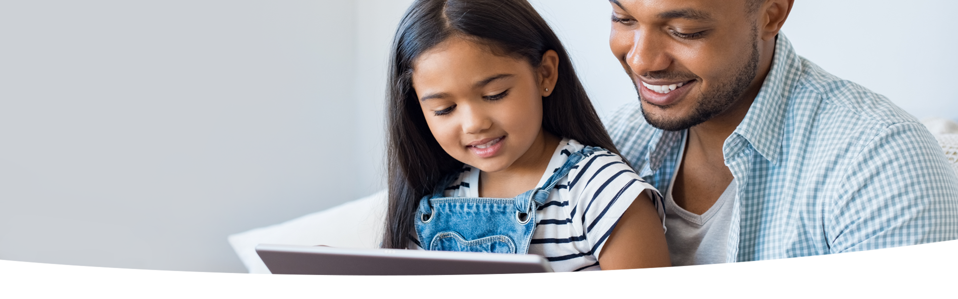 Parent and child look at a tablet together.