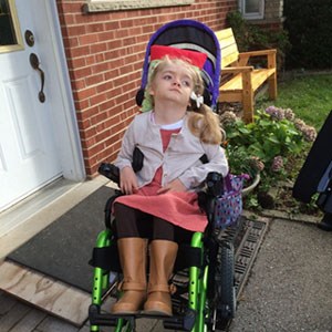 Young girl seated in wheelchair.