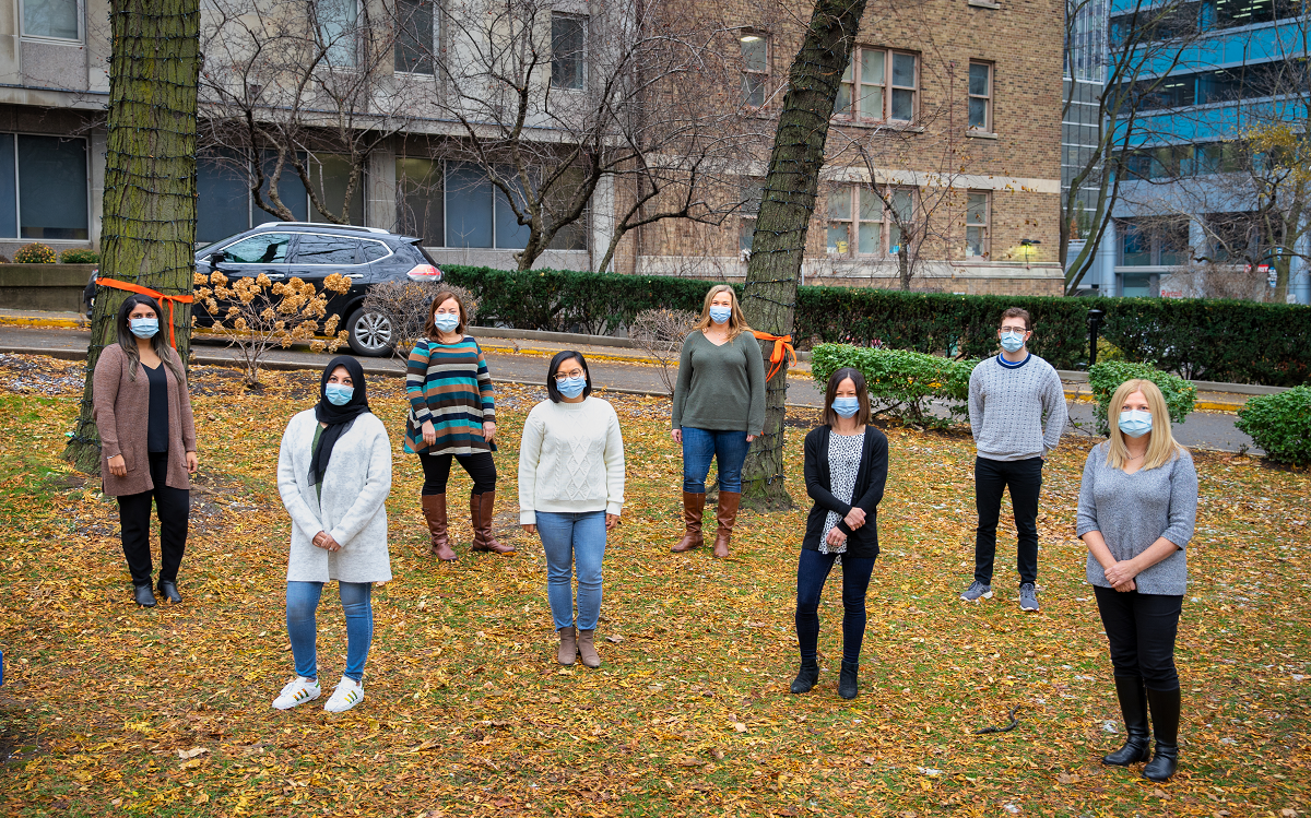 Staff stand together on a lawn, wearing protective face masks.