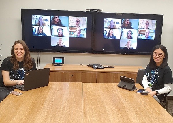 Consultation Liaison Nurse Practitioner Bridget Doan and Urgent Care Clinic Nurse Practitioner Janet Seo speak with colleagues on a monitor screen 