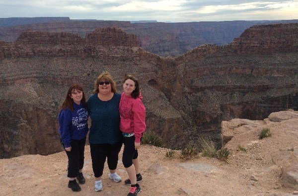 Mom and two children stand together in front of the Grand Canyon.