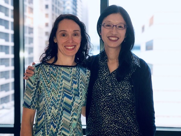 Two women stand side by side.