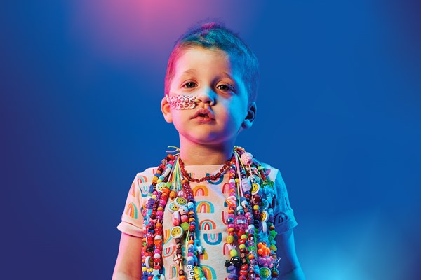 A young child wearing colourful bravery beads around her neck.
