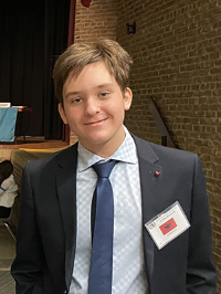  14-year-old Lukas Korkuti posing for a photo at an event. 