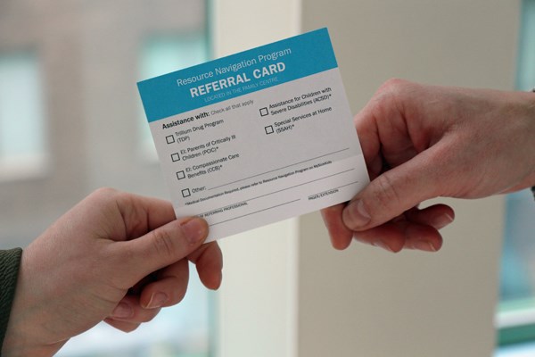 A card is held between two different hands.