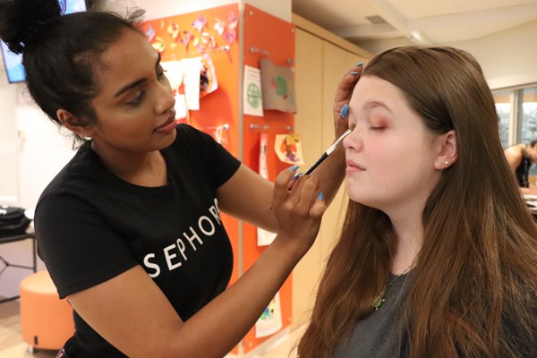 Makeup artist applies eyeshadow.