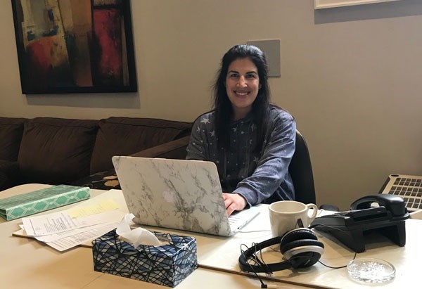 Registered Dietitian Alisa Bar-Dayan sits at a desk with her laptop to provide virtual care to patients