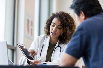 A female physician shows a patient data on a tablet.