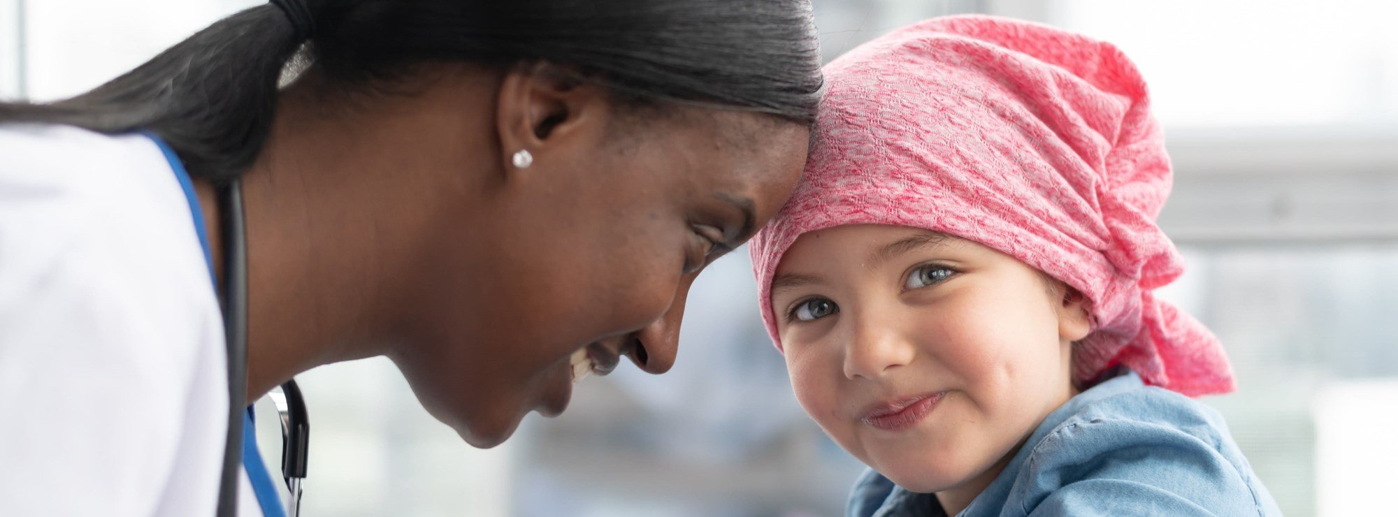 a young cancer patient smiling with their happy doctor