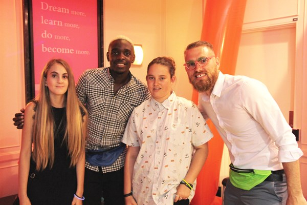 Teens pose with two soccer players.