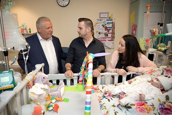 Doug Ford stands next to patient Violet's parents