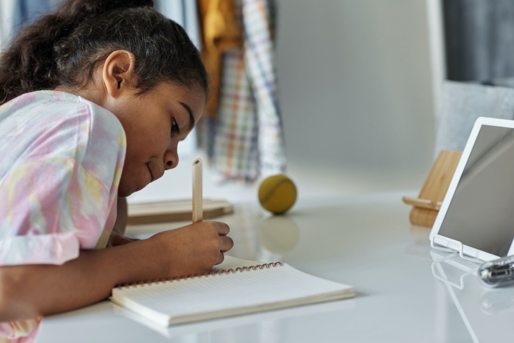 young girl writing at her desk