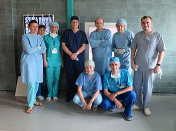 A group shot of nine people dressed in hospital scrubs