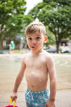 Young boy in a bathing suit, outside.