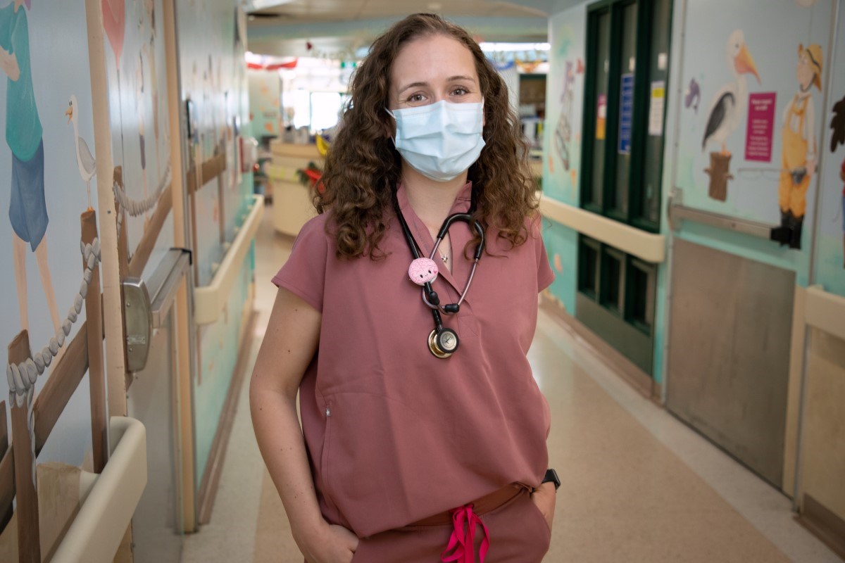 Madison Beatty in a mask, standing in a clinic hallway