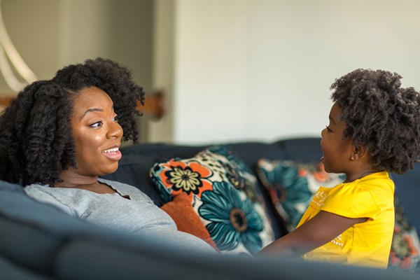 Mom and child looking at each other relaxedon a couch