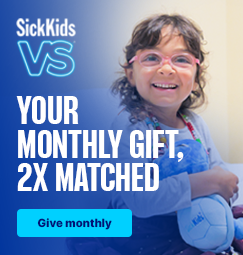 A smiling child holding onto a SickKids branded turtle plush toy. She is wearing glasses and Bravery Beads. SickKids VS. Your monthly gift, 2x matched. Give monthly.