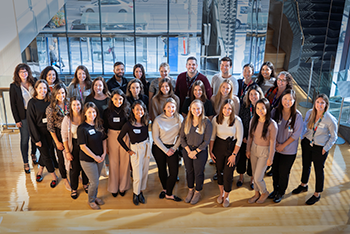 Group of approximately 30 people pose for a group photo. All are wearing business casual attire.